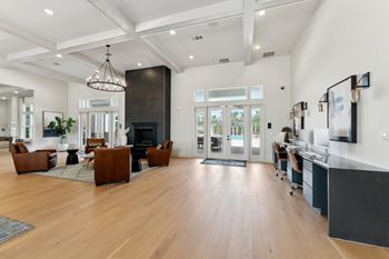 A modern living room with a fireplace and a kitchen area in the background.